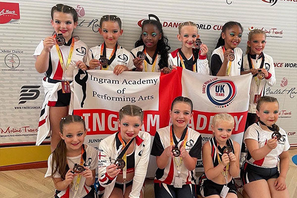 Ingram Academy junior dancers with their medals and banner at the Dance World Cup