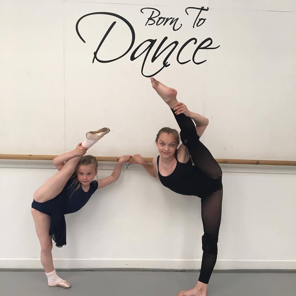 Two dancers stretching in the studio