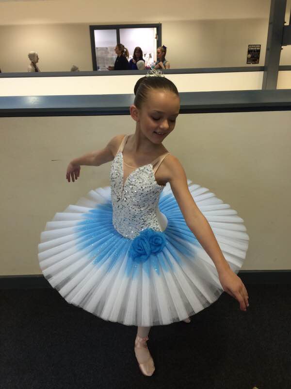 Darcie in a white and blue tutu, a Royal Ballet Junior Associate