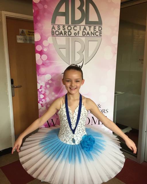 Young ballet dancer with a festival medal