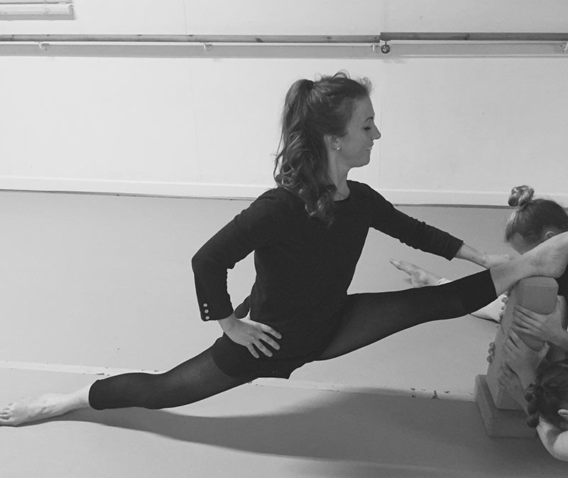 Kate Ingram demonstrating a floor stretch in the studio